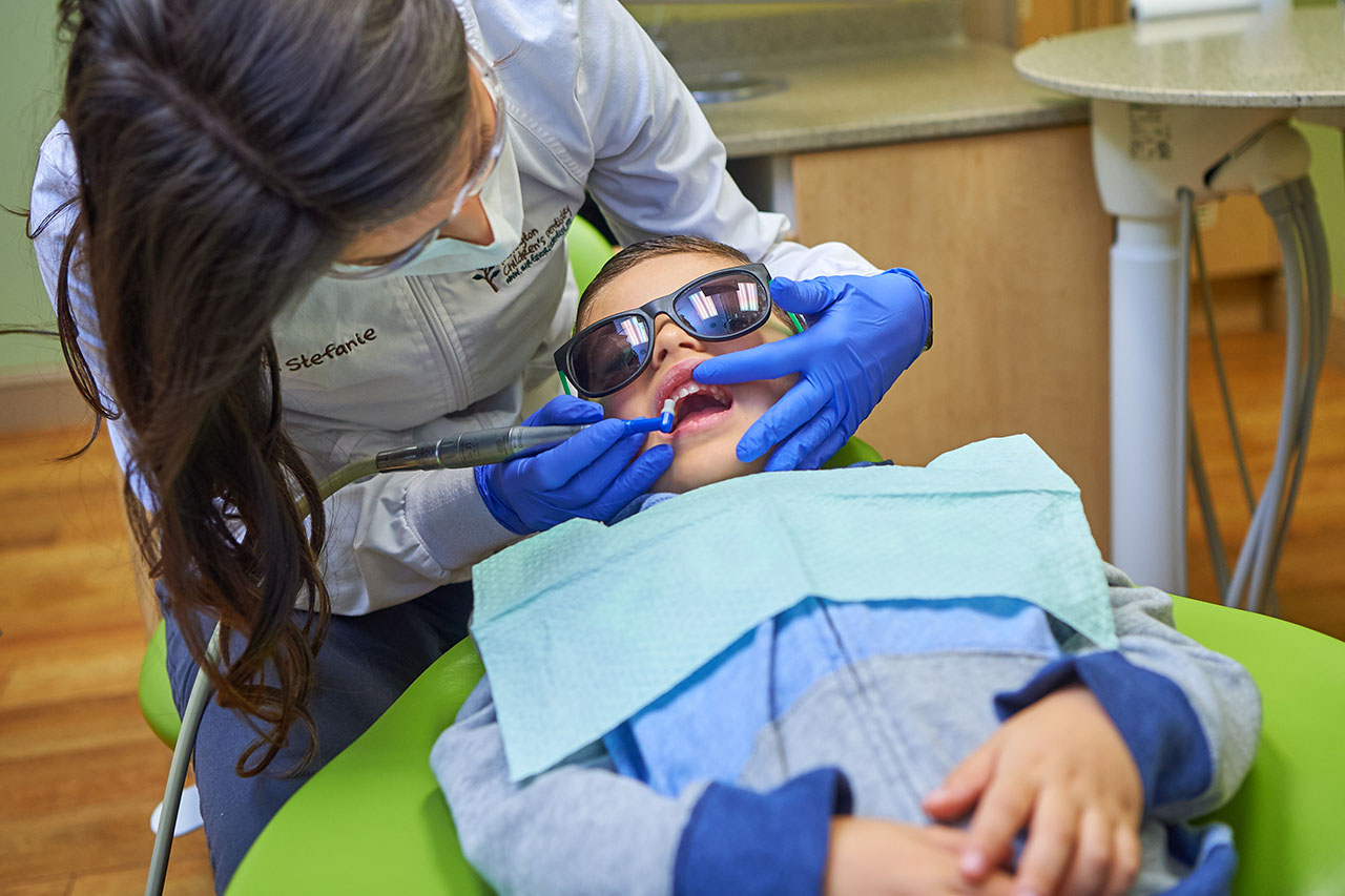 Dentist Cleaning Child's Teeth